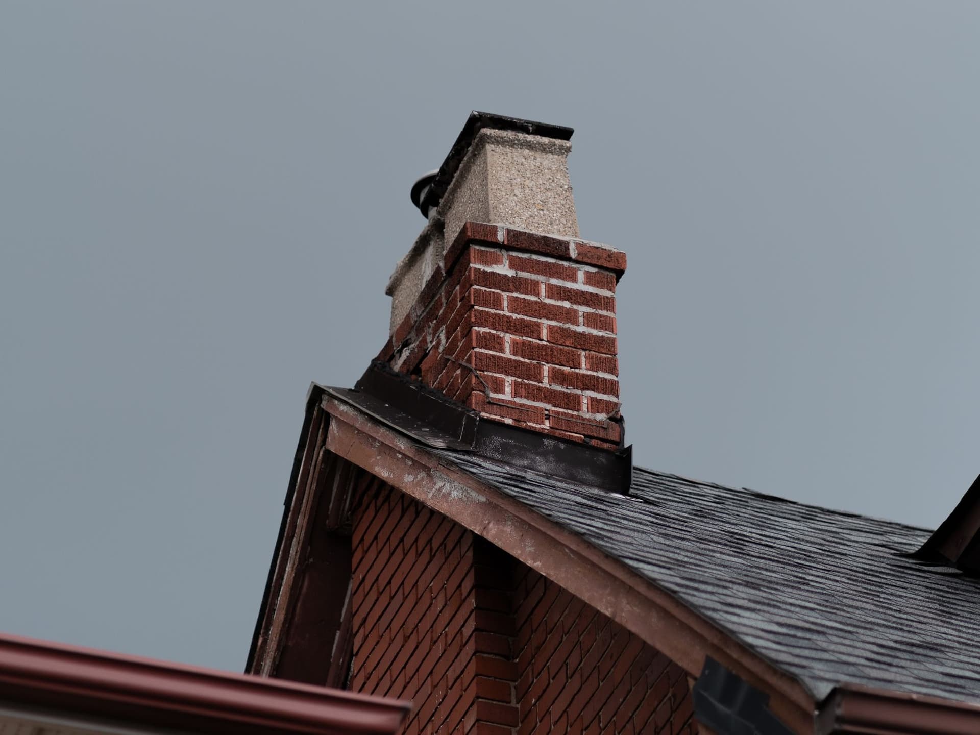 A brick chimney on the roof of a house