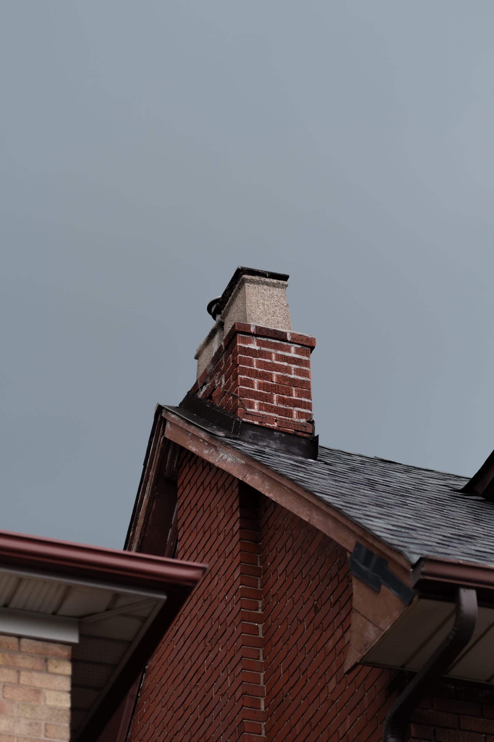 A brick chimney on the roof of a house