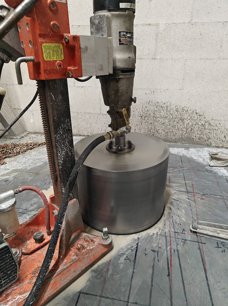 A concrete core drill cutting through a slab